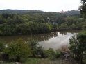 Lehce zakalená voda Brněnské přehrady a hrad Veveří pohledem z chráněného území Kůlny.