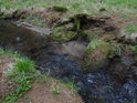 Kameny v korytě potoka významně ovlivňují jeho tok.