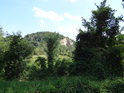 Pohled od Malhostického rybníka přes řeku Bílinu na kopec zvaný Ve skále, za kterým se nachází obec Vrahožily.
