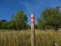 Vnější značka chráněného území na dřevěném kůlu.