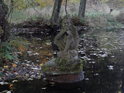 Soška na ostrůvku rybníčka v Pekle výrazem připomíná baziliška.