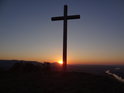 Velký ocelový kříž na vrcholu Radobýlu při vycházejícím Slunci nad městem Litoměřice.