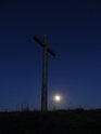 Ocelový kříž na vrcholu Radobýlu těsně před úplným vyhasnutím slunečních paprsků a za silné vlády Měsíce, blízkého úplňku.