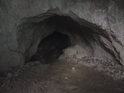 Zpola zasypaný vstup do menší jeskyňky.
